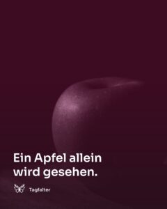 Ein einzelner roter Apfel liegt auf einem schlichten Holztisch.