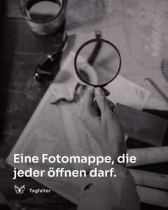 Aufgeschlagenes Fotoalbum mit Lupe auf einem Holztisch